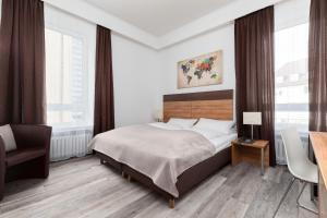 a bedroom with a bed and a desk and windows at Hotel am Ludwigsplatz in Gießen