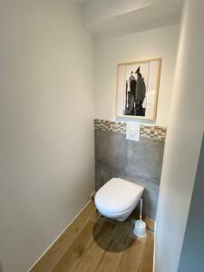 baño con aseo y una foto en la pared en Maisonnette,100m mer, proche St Malo/Cancale, WIFI, en Saint-Benoît-des-Ondes