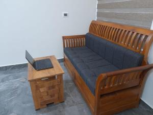 a wooden bench with a laptop on a table at Milestone Inn in Sultan Bathery
