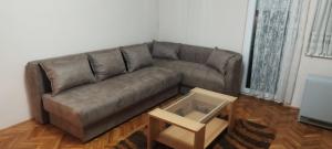 ein Ledersofa im Wohnzimmer mit Couchtisch in der Unterkunft Apartman LENA in Aranđelovac