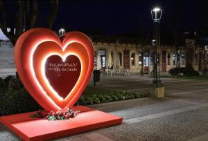 une grande statue de cœur rouge sur un trottoir dans l'établissement Alamedastudio, à Vila do Conde