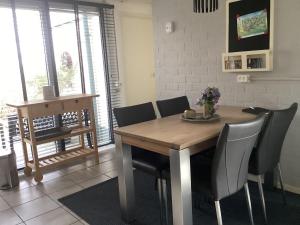 a dining room with a wooden table and chairs at Casa della nonna bungalow 2 in Simpelveld +17 photos
