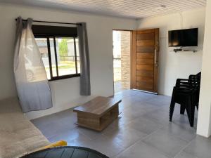 a living room with a couch and a table and a television at ᗷᖇᑌᗰᗩ in Barra del Chuy