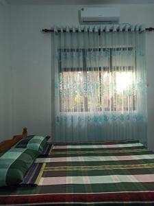 a bedroom with a bed and a window at 4Seasons Holiday Home in Ratnapura