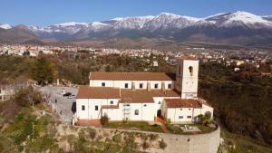 a large white church with mountains in the background at Civico 4 in Castrovillari