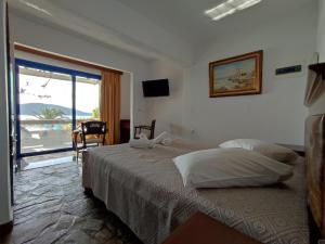 a bedroom with a bed with a view of the ocean at Alexandros by the Beach - Serifos in Livadakia