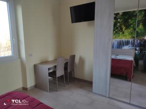 um quarto com uma secretária, uma cama e uma televisão em Villa ARA rossa em Canegrate