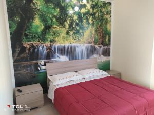 una camera da letto con un dipinto di una cascata di Villa ARA rossa a Canegrate