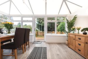 a conservatory with a table and chairs and windows at Accessible 3-bedroom bungalow with patio +driveway in Southampton