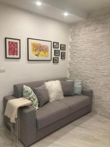 a living room with a gray couch and pictures on the wall at CASA TUA in Ivrea