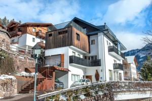 a house in the mountains with a black roof at Apartment Murata in Ortisei