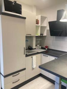 a kitchen with white cabinets and a white refrigerator at CASA TUA in Ivrea