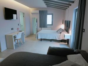 カストロ・ウルディアレスにあるアルディガレス 11のベッド、デスク、ソファが備わるホテルルームです。