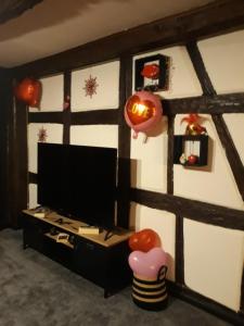 Zimmer mit einem TV und einer Wand mit Kürbissen in der Unterkunft LOVE ROOM Le rouge et noir in Barr
