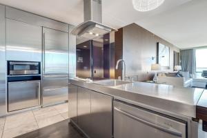 a kitchen with stainless steel appliances and a sink at Vegas Palms HIGH 52nd fl. 1BDR corner penthouse 1220sqft in Las Vegas