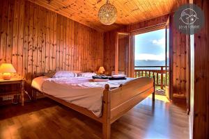 a bedroom with a bed and a large window at Chalet Cassiopée in Ovronnaz