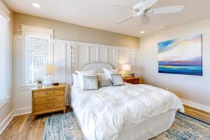 Schlafzimmer mit einem weißen Bett und einem Deckenventilator in der Unterkunft Dolphin View in Rockport
