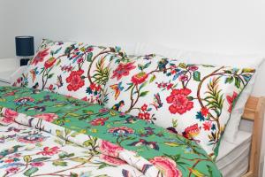 eine weiße Couch mit Blumenkissen drauf in der Unterkunft Home Sweet Bungalow in Queensbury