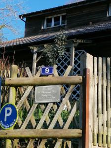 ein Schild auf einem Holzzaun vor einem Haus in der Unterkunft Sherwood in Étretat