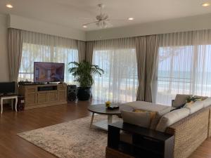 a living room with a couch and a tv at Seapine Beach Golf and Resort Hua Hin in Hua Hin