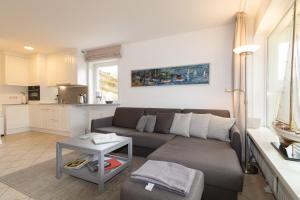 a living room with a couch and a table at Ferienwohnung Strandrose in Hörnum +6 photos