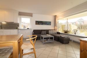 a kitchen and a living room with a couch at Ferienwohnung Strandrose in Hörnum