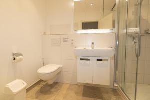 a bathroom with a toilet and a sink and a shower at Ferienwohnung Strandrose in Hörnum