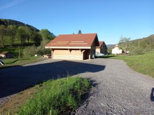 uma casa com uma grande entrada ao lado de uma estrada em TOUT NEUF - Chalet Paul avec sauna em La Bresse