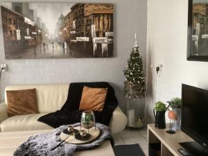 ein Wohnzimmer mit Sofa und Weihnachtsbaum in der Unterkunft Casa della nonna bungalow 2 in Simpelveld