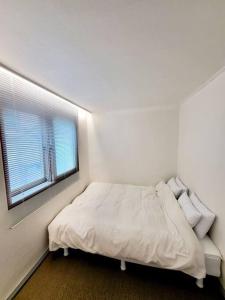 a white bedroom with a bed and a window at Sinchon station 4 min three-room hongdae in Seoul