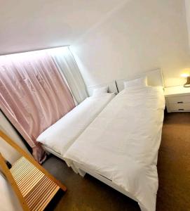 a bedroom with a bed with white sheets and a window at Sinchon station 4 min three-room hongdae in Seoul