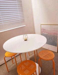 a white table and two orange chairs in a room at Sinchon station 4 min three-room hongdae in Seoul
