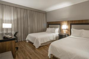 um quarto de hotel com duas camas e uma secretária em Marriott São Paulo Airport Hotel em Guarulhos