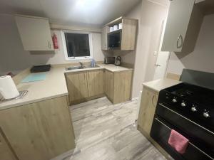 uma cozinha com armários de madeira e um fogão preto em ISMA em Knaresborough