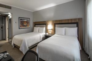 a hotel room with two beds and a desk at Marriott São Paulo Airport Hotel in Guarulhos