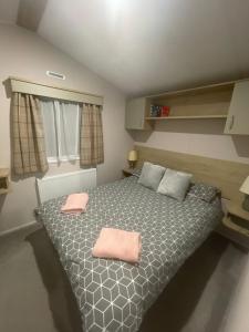 1 dormitorio con 1 cama con 2 toallas rosas en ISMA, en Knaresborough