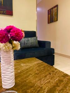 a vase with flowers on a table in a living room at Nawara Hotel Khanshalila in Riyadh
