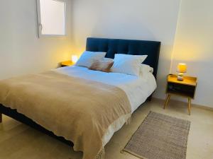 een slaapkamer met een groot bed met een blauw hoofdeinde bij Apartamento Torreblanca del sol in Fuengirola