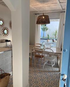 uma cozinha e sala de jantar com mesa e cadeiras em une maison bleue em Piolenc