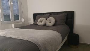 um quarto com uma cama com duas almofadas brancas em Belle Place 89 Appartement em Auxerre