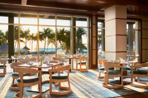 The Ritz Carlton Key Biscayne, Miami في ميامي: مطعم به طاولات وكراسي ومطل على المحيط