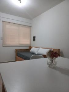 una habitación con una cama y una mesa con un jarrón de flores en Yapandi Portezuelo en Salta