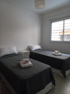 Dos camas en una habitación con toallas. en Yapandi Portezuelo en Salta