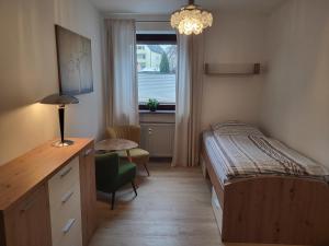 1 dormitorio con cama, escritorio y ventana en Andys Ferienwohnung, en Neustadt an der Waldnaab