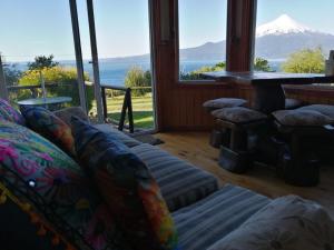 a living room with a couch and a view of a mountain at Refugio y tinajas Vientos del lago in Los Riscos