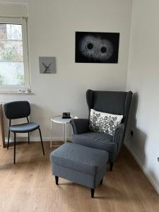 ein Wohnzimmer mit einem Stuhl, einem Stuhl und einem Stuhl in der Unterkunft Appartement am Teich in Krefeld