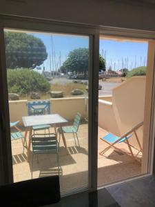 Elle offre une vue sur une terrasse avec une table et des chaises. dans l'établissement Appartement cosy à Boyardville, à Boyardville