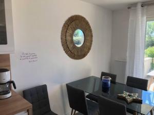 uma mesa de jantar com cadeiras e um espelho na parede em Appartement cosy à Boyardville em Boyardville