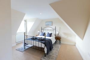 a bedroom with a bed with blue pillows at Luxury 5 bedroom house - sleeps 10 in Colkirk