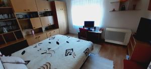 a bedroom with a bed and a desk and a window at Nyaralóház HANGA in Fonyód